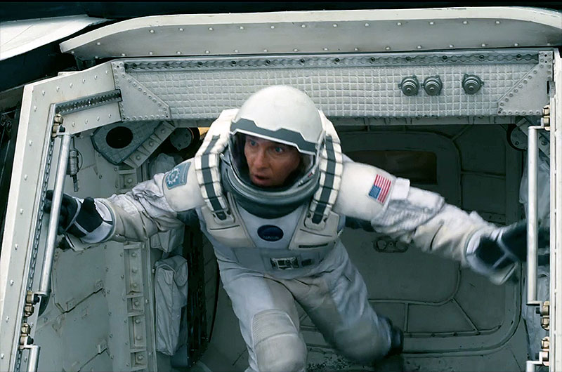 Matthew McConaughey as Cooper in a NASA spacesuit exiting a spacecraft hatch in Interstellar.