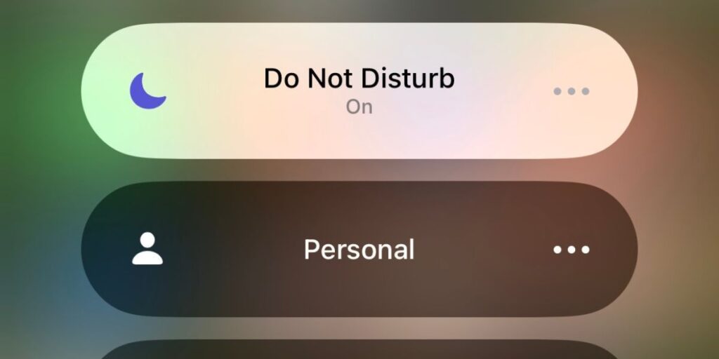 Smartphone with muted notifications and a "Do Not Disturb" sign, symbolizing digital detox and focused work time.