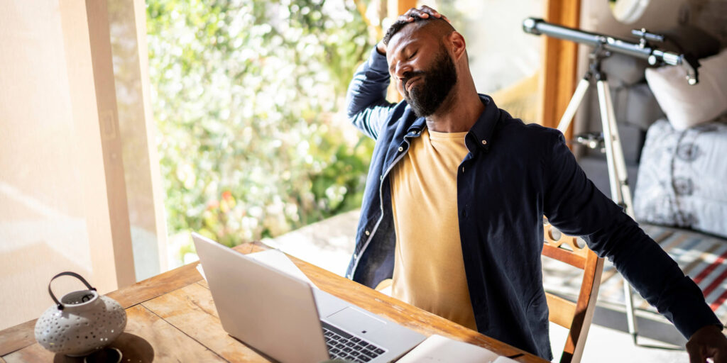 Person working from home at a bright, organized desk setup, promoting mental wellness and focus.